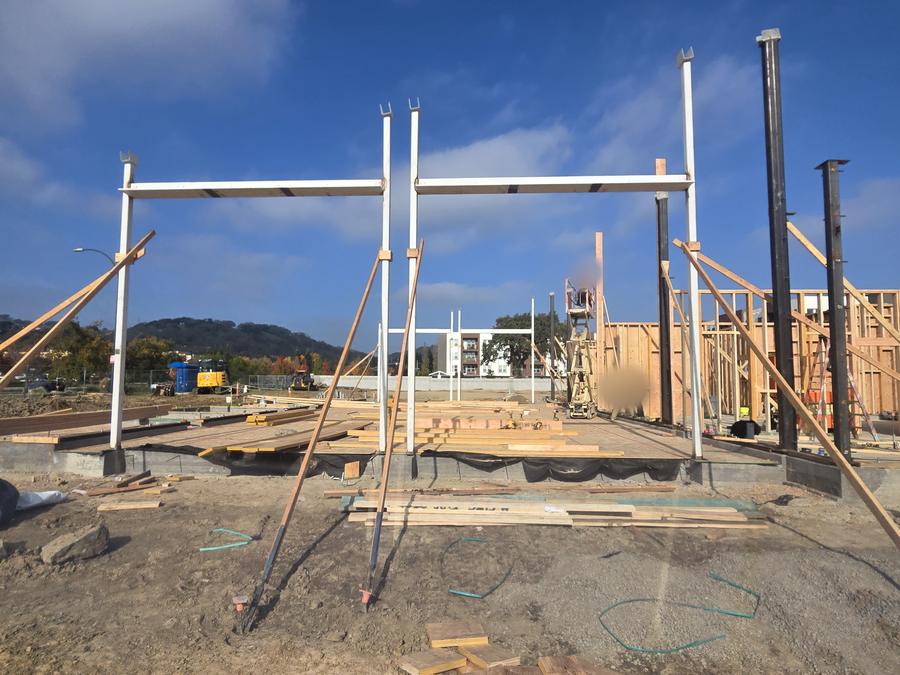Steel and glulam framing rises from the slab